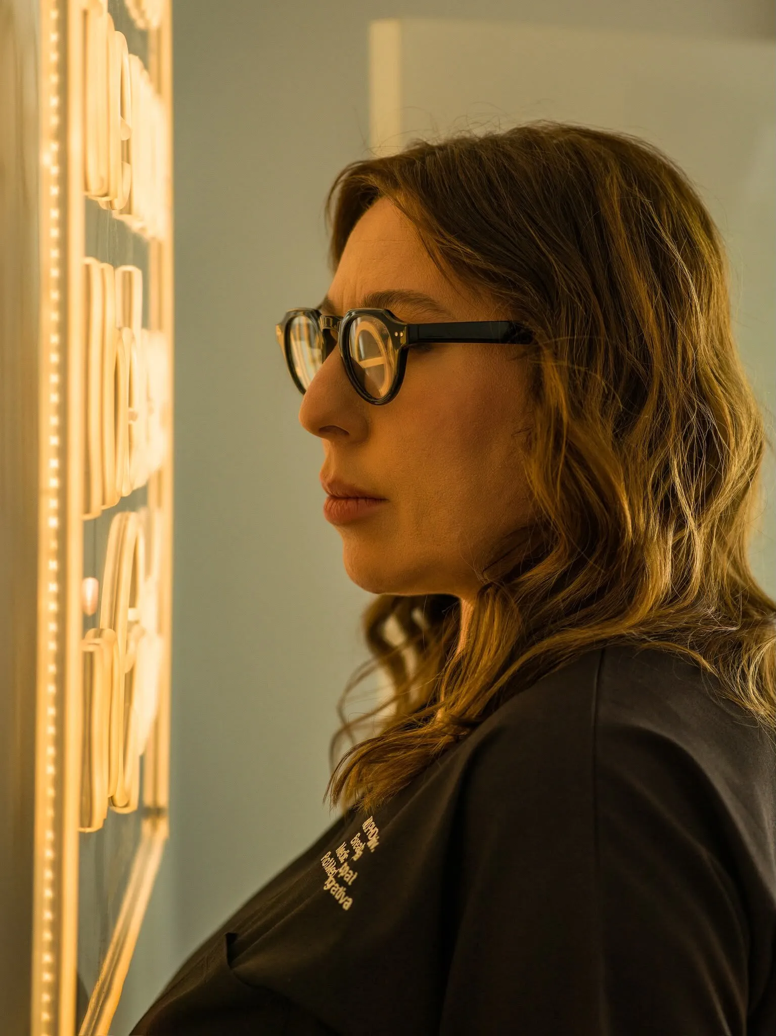 Dr. Olivia Breaban in profile, lit by a neon sign